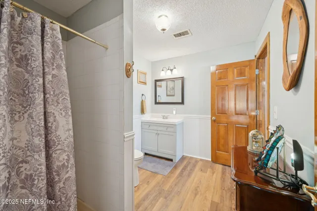 a bathroom with a double vanity sink toilet mirror and shower