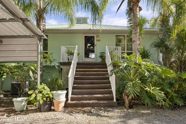 a front view of a house with wooden floor and a potted plant