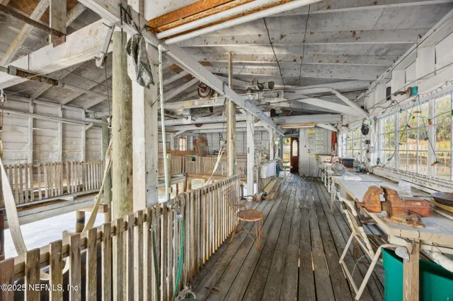 a balcony with wooden floor table and chairs