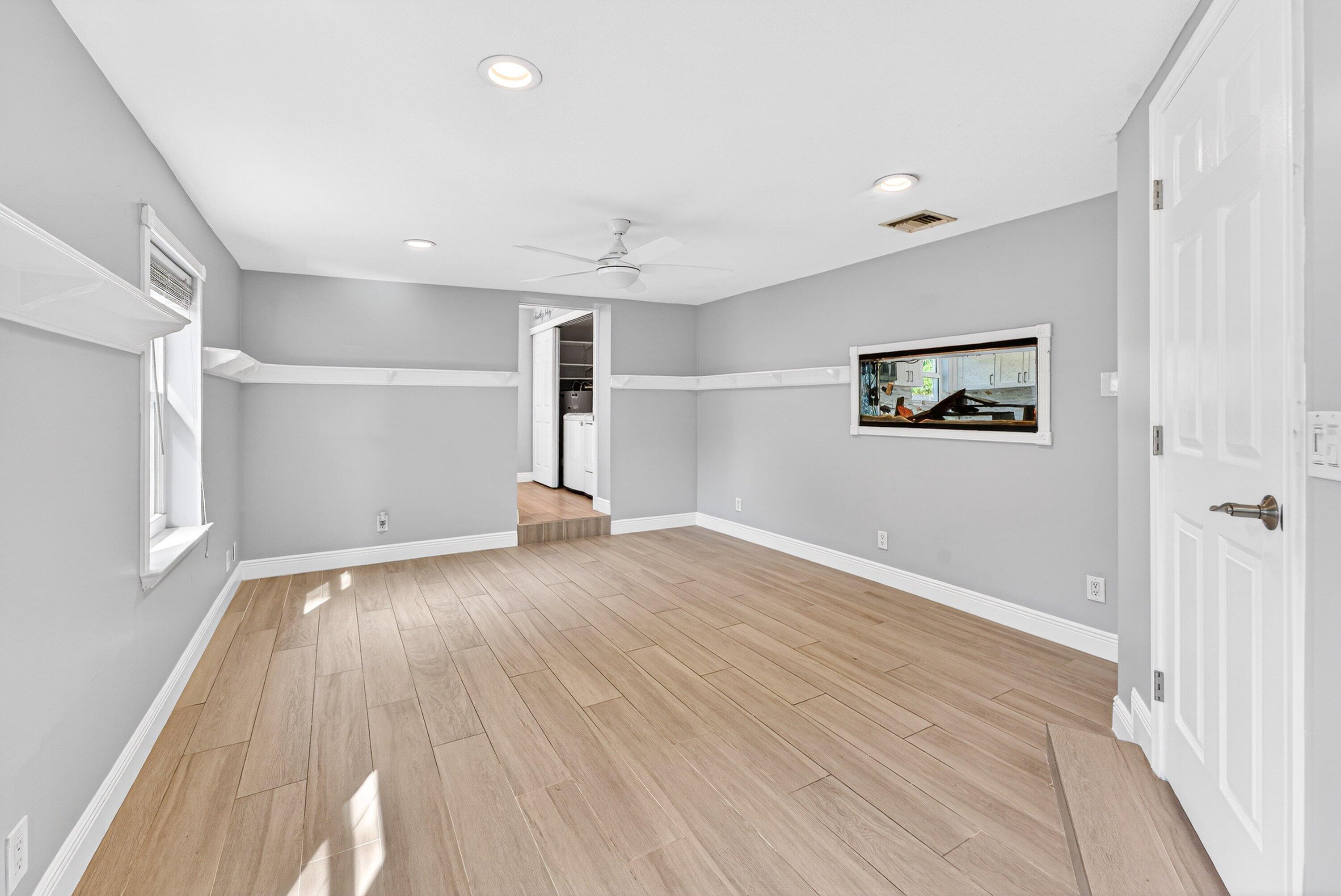 5565 Papaya Road Royal Palm Estates, FL 33413 - Photo 15 of 30 an empty room with wooden floor and windows