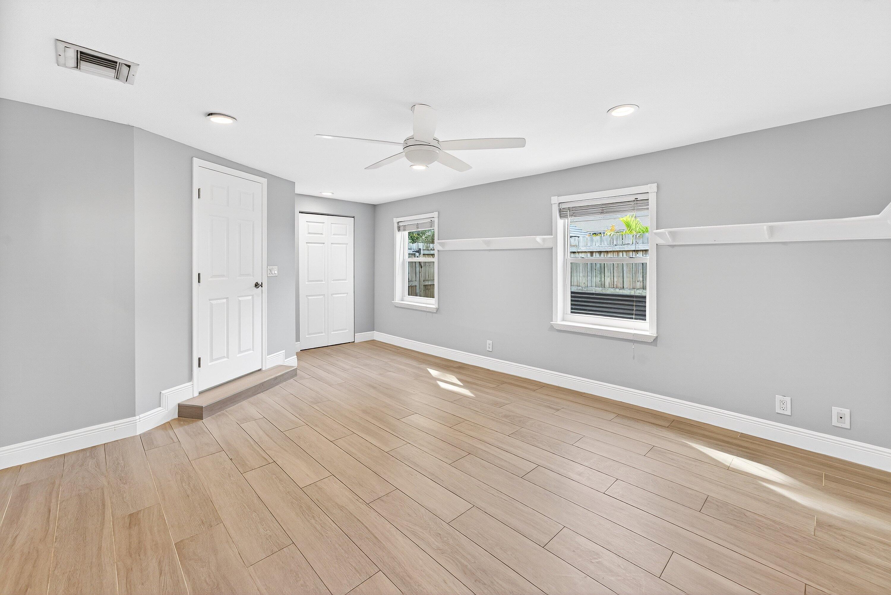 5565 Papaya Road Royal Palm Estates, FL 33413 - Photo 16 of 30 an empty room with wooden floor and windows