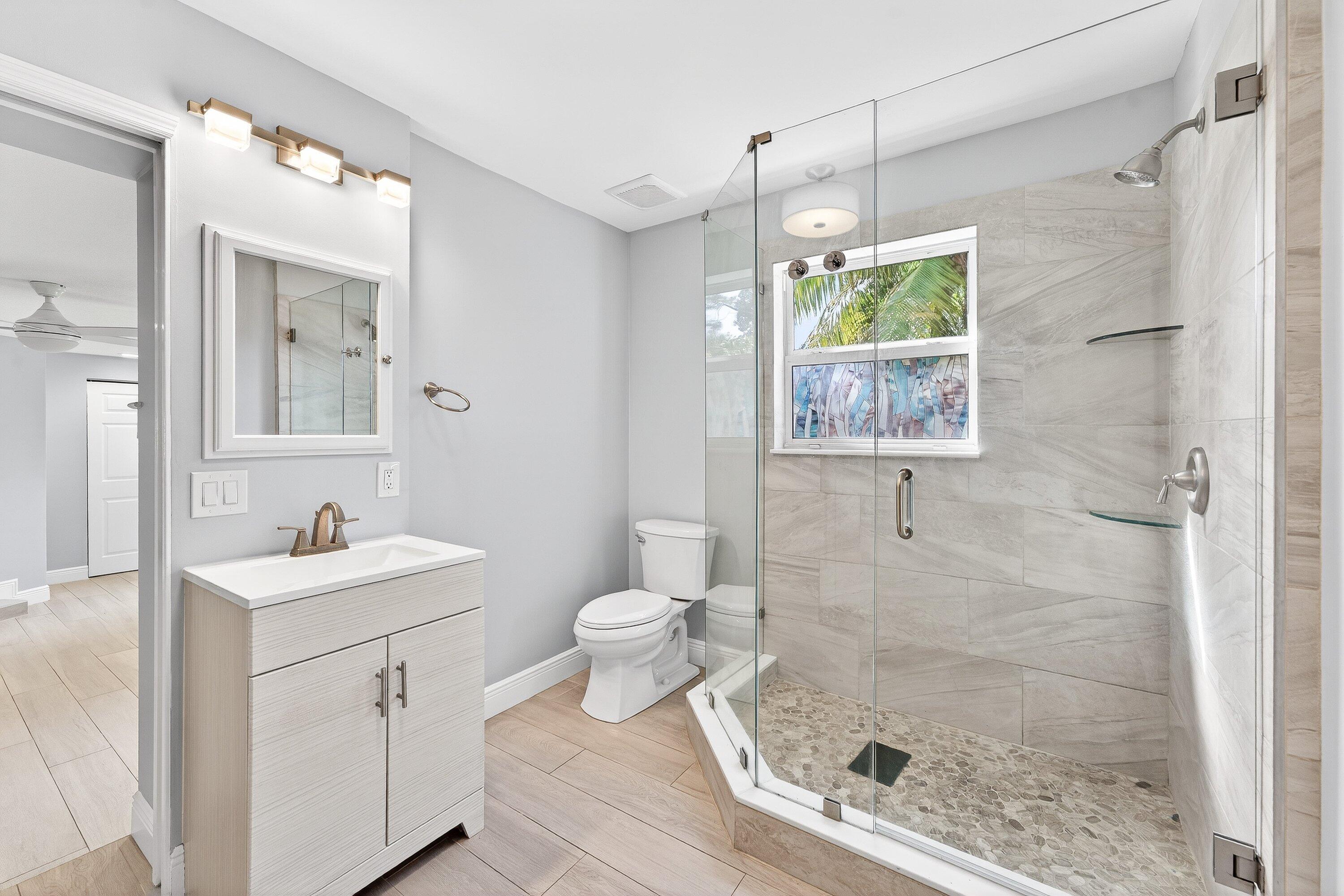5565 Papaya Road Royal Palm Estates, FL 33413 - Photo 17 of 30 a bathroom with a sink toilet and shower