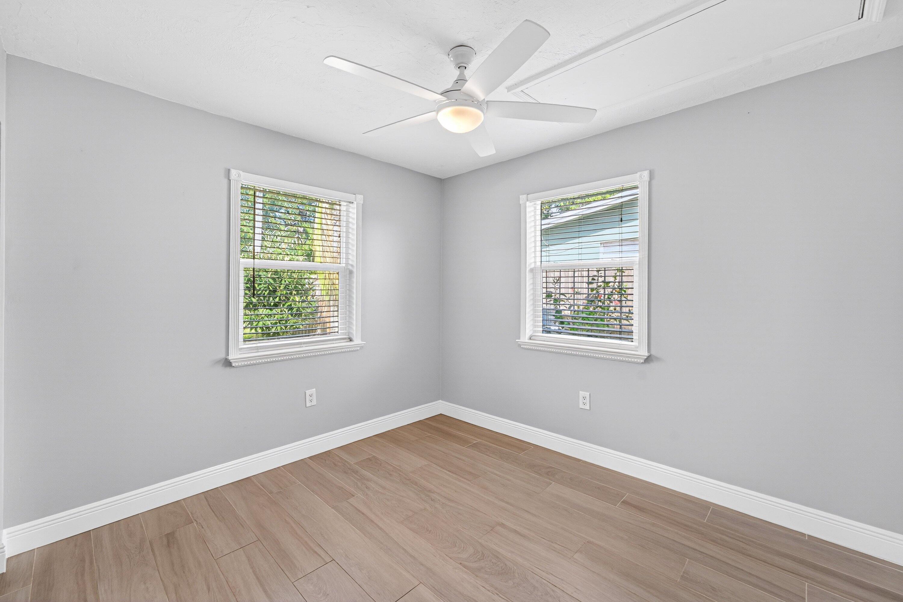 5565 Papaya Road Royal Palm Estates, FL 33413 - Photo 20 of 30 an empty room with wooden floor and windows