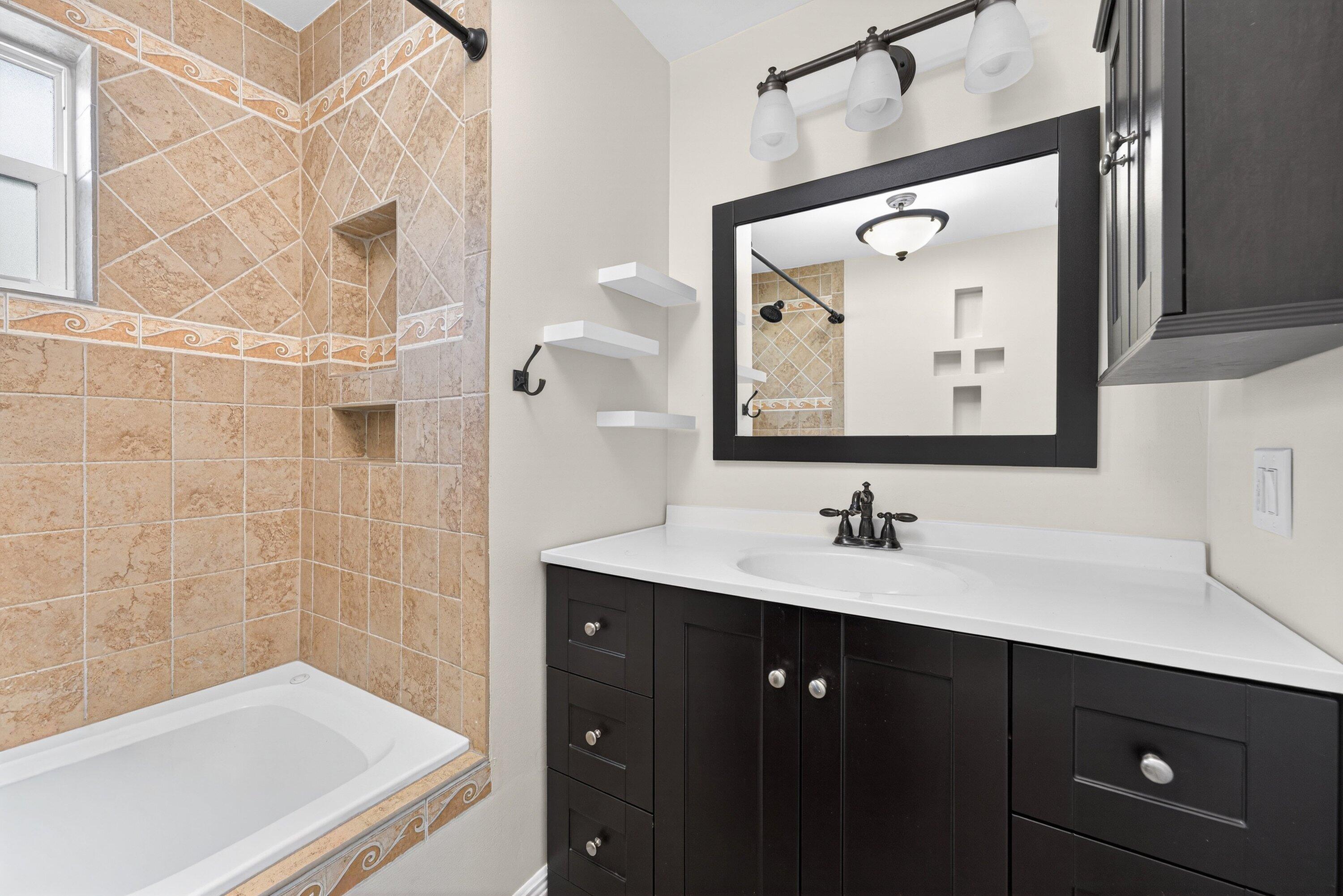 5565 Papaya Road Royal Palm Estates, FL 33413 - Photo 24 of 30 a bathroom with a tub sink and mirror
