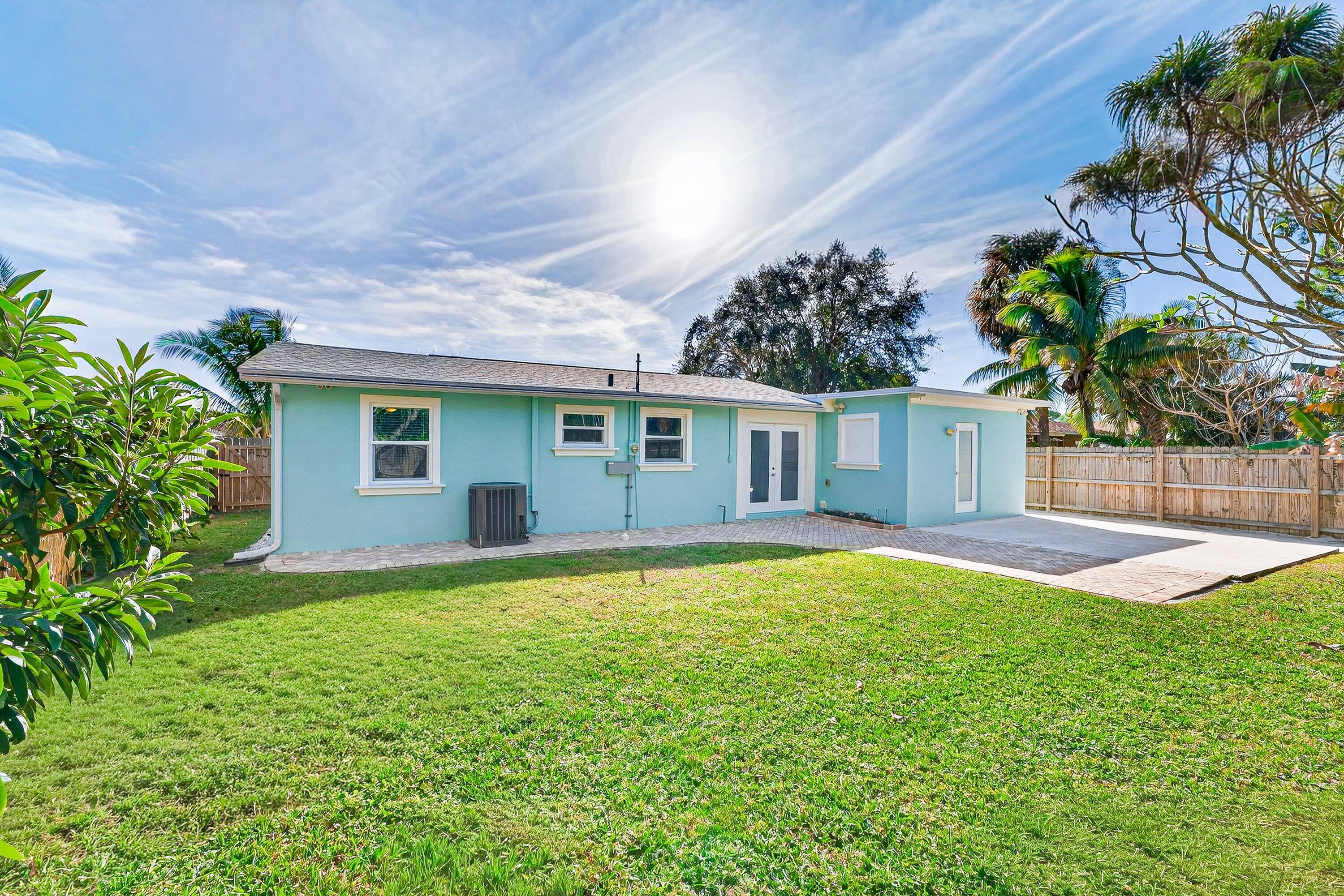 5565 Papaya Road Royal Palm Estates, FL 33413 - Photo 27 of 30 a house that has a big yard with large trees