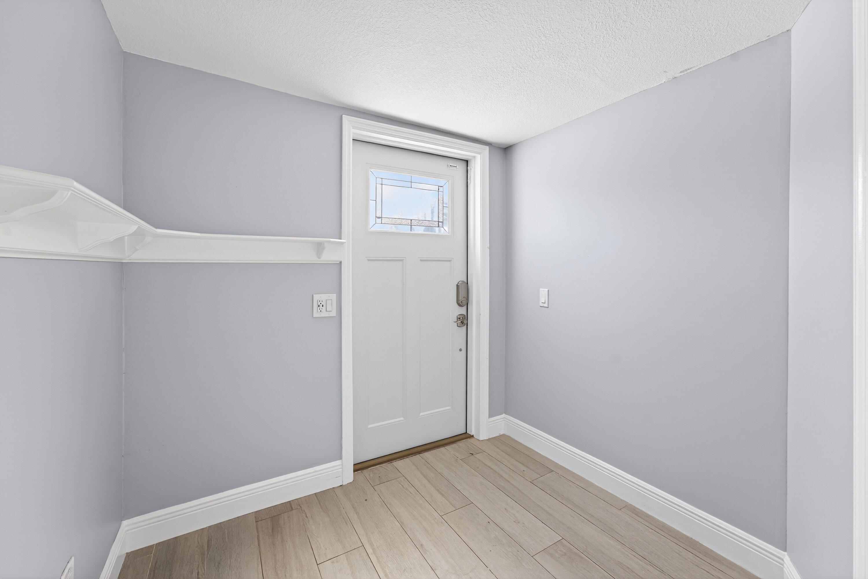 5565 Papaya Road Royal Palm Estates, FL 33413 - Photo 4 of 30 a view of an empty room with wooden floor and closet