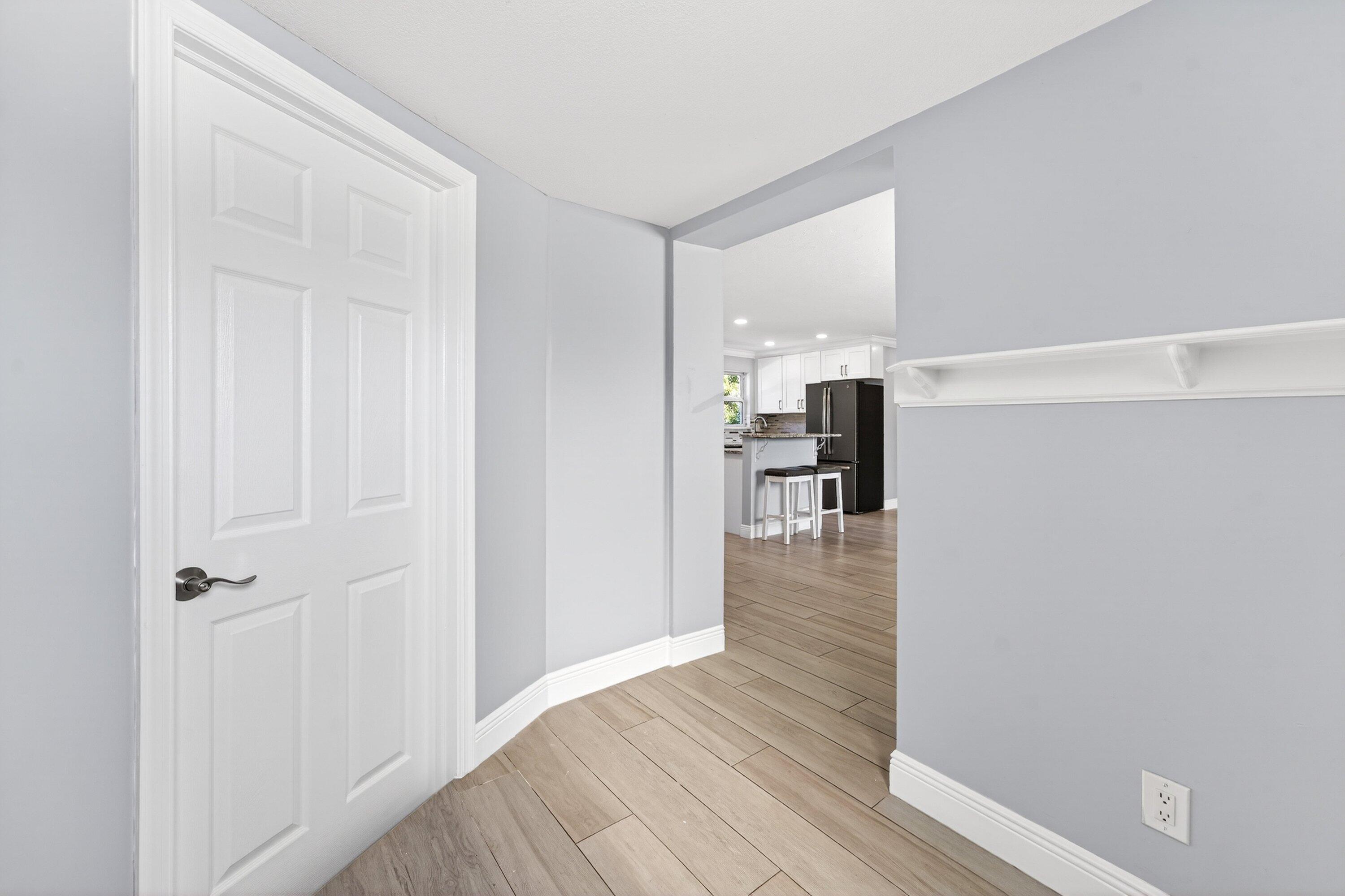5565 Papaya Road Royal Palm Estates, FL 33413 - Photo 5 of 30 a view of a hallway with wooden floor and staircase