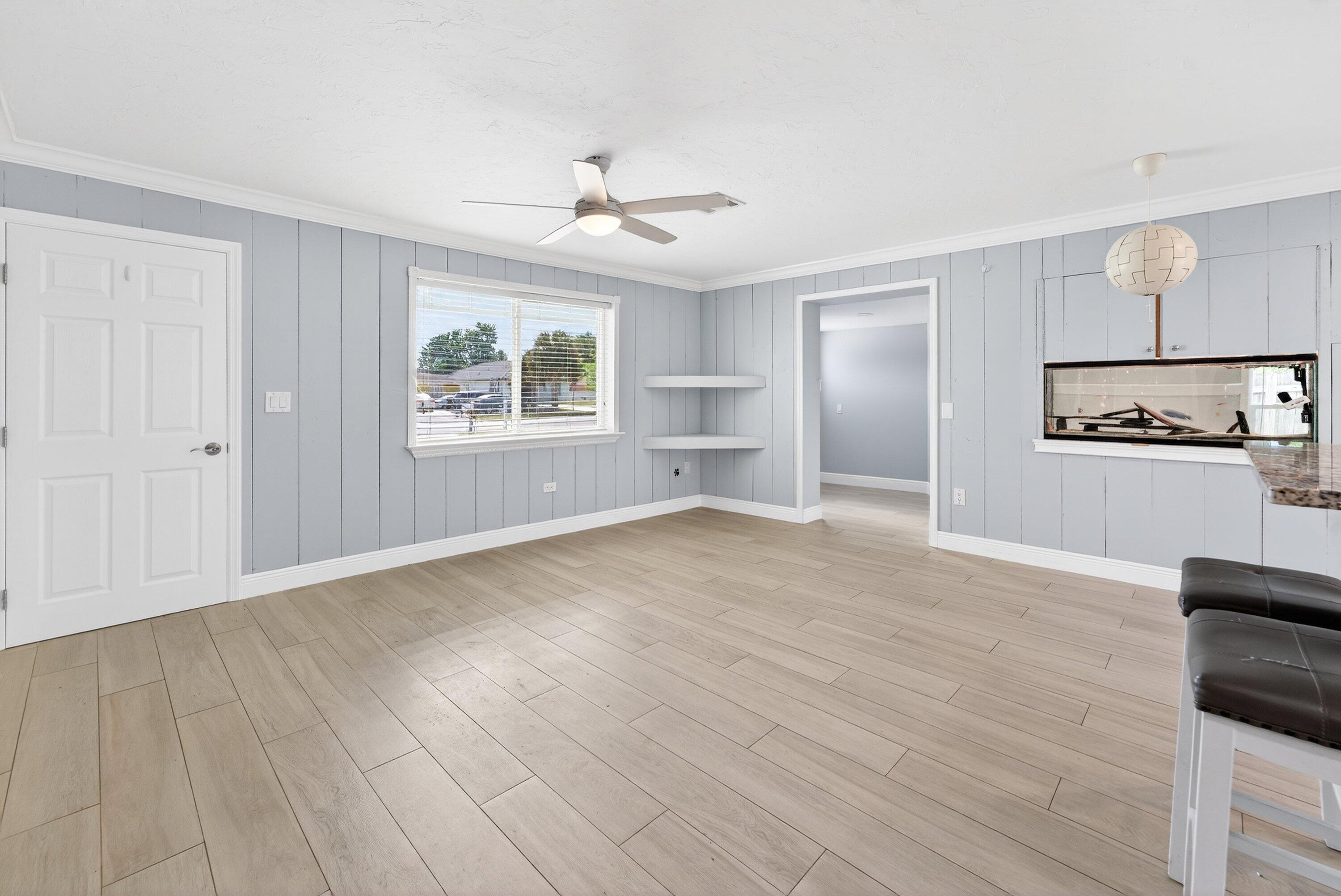 5565 Papaya Road Royal Palm Estates, FL 33413 - Photo 7 of 30 an empty room with wooden floor cabinet and windows