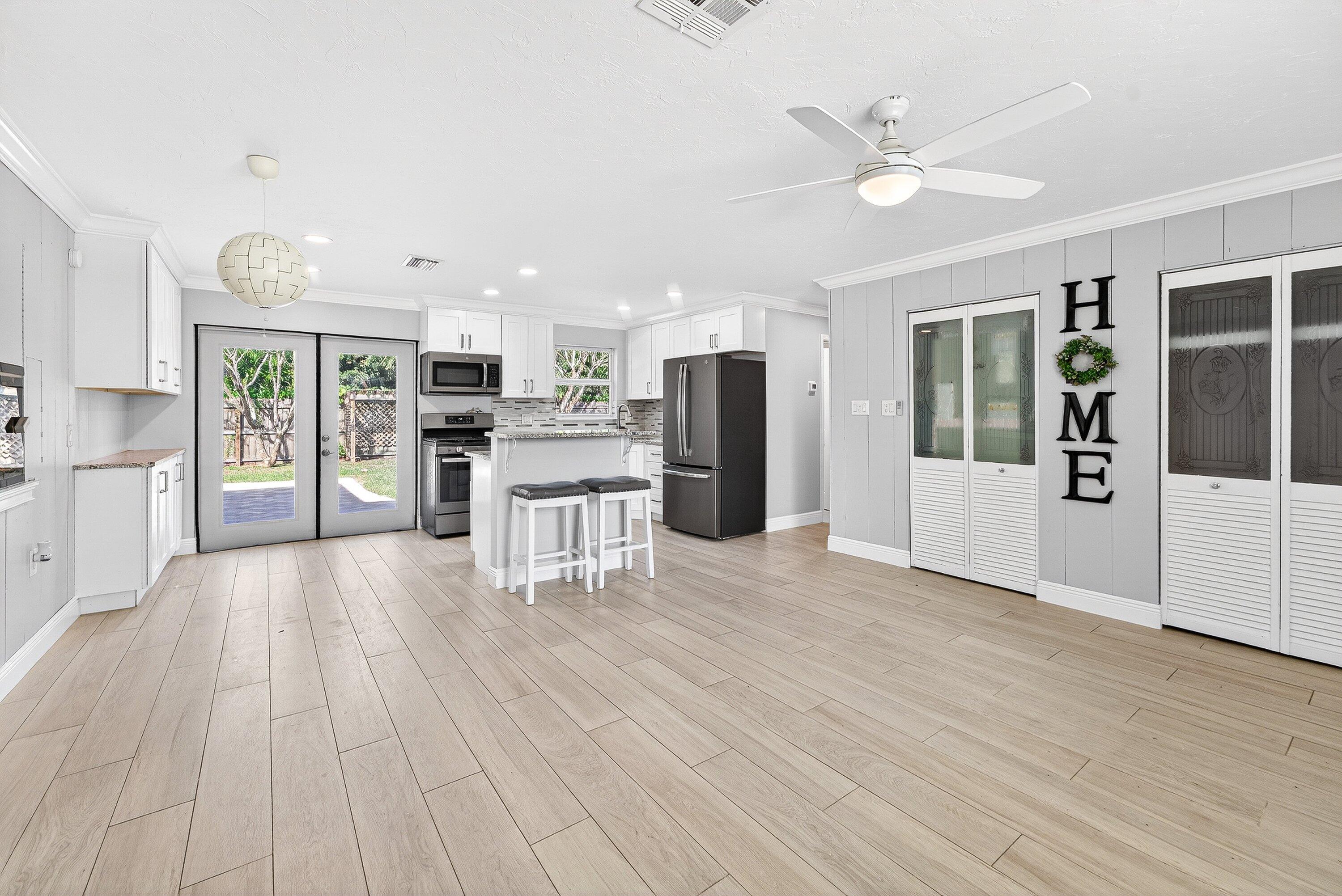 5565 Papaya Road Royal Palm Estates, FL 33413 - Photo 8 of 30 a view of a kitchen with wooden floor and an empty room