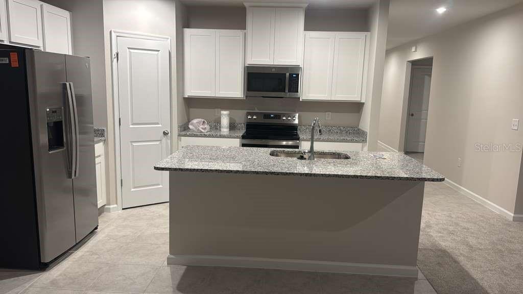 347 Biltmore Boulevard Dundee, FL 33838 - Photo 3 of 18 a kitchen with granite countertop a refrigerator and a stove top oven