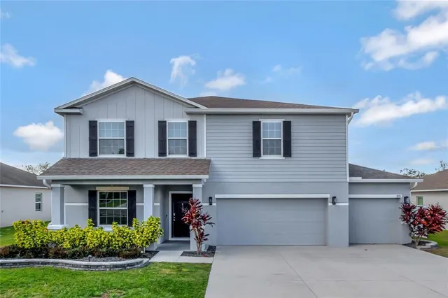 a front view of a house with a garden and plants