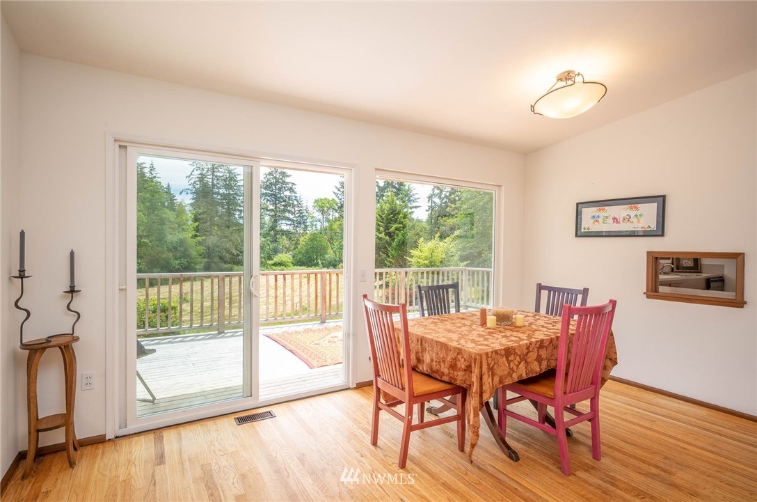 21429 Monument Road Southwest Vashon, WA 98070 - Photo 18 of 37 a view of a dining room with furniture window and wooden floor