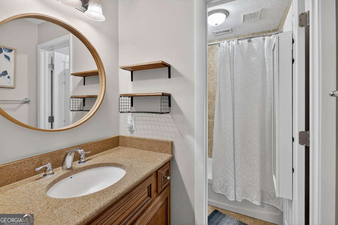 2514 Demere Road, Unit 7 St. Simons, GA 31522 - Photo 21 of 22 a bathroom with a granite countertop sink and a mirror