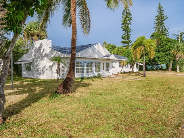 a front view of a house with a big yard and large trees