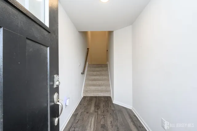 a view of a hallway with wooden floor and entryway