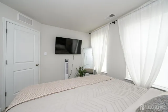 a bedroom with a bed and a flat screen tv