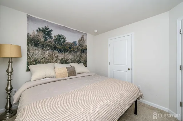 a bedroom with a bed and a painting on the wall