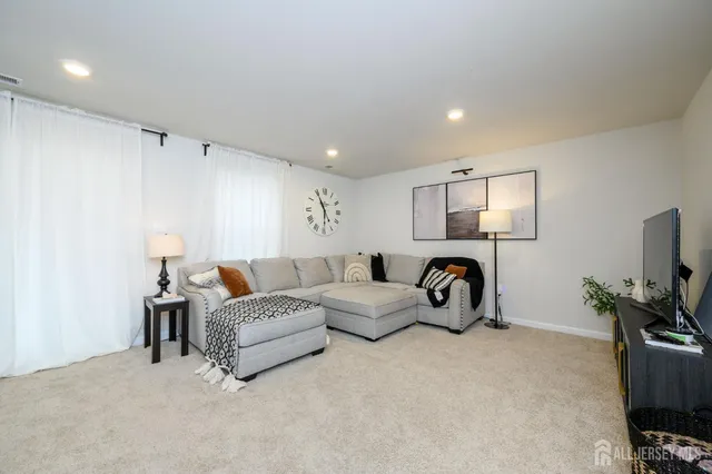a living room with furniture a white couch and a flat screen tv