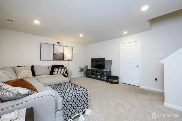 a bedroom with a bed a couch and a flat screen tv