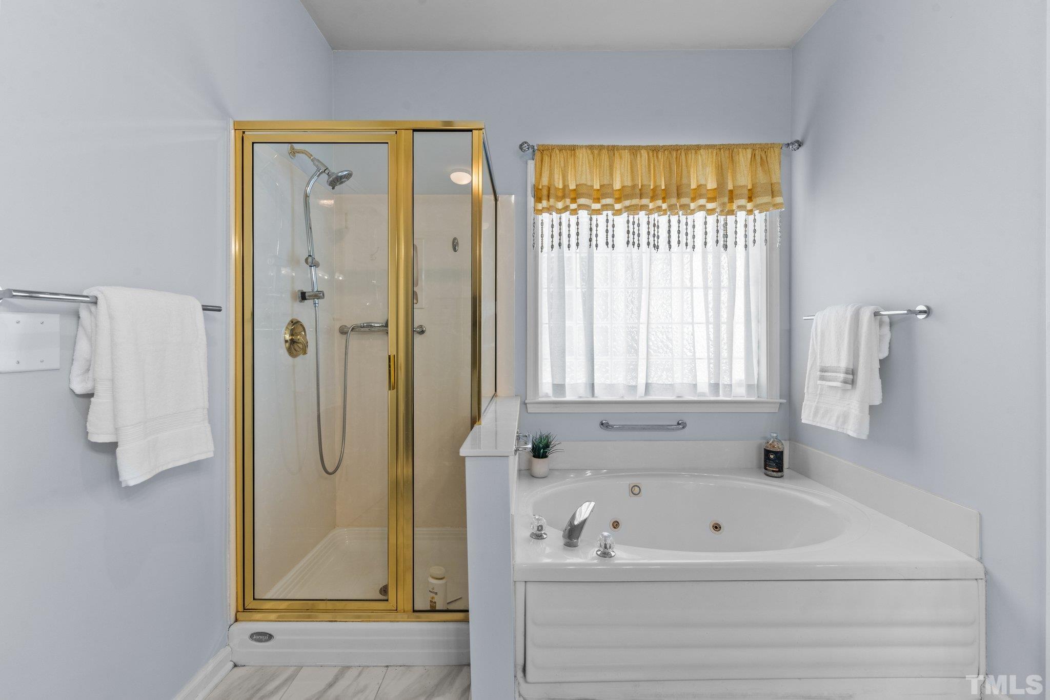 10507 Dapping Drive Raleigh, NC 27614 - Photo 22 of 38 a bathroom with a tub a sink and a window