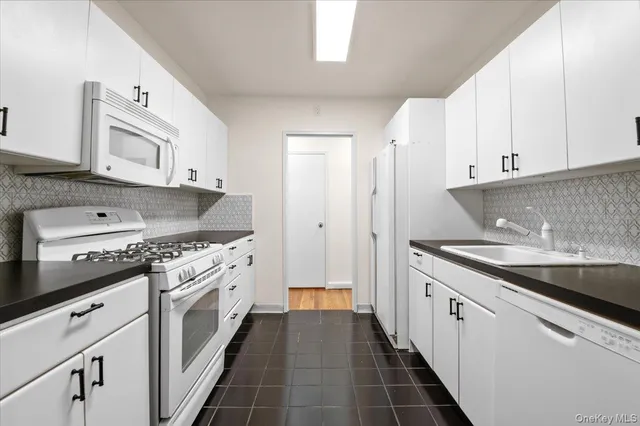 a kitchen with granite countertop a sink stove and cabinets