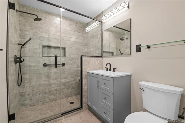 a bathroom with a sink a toilet and shower