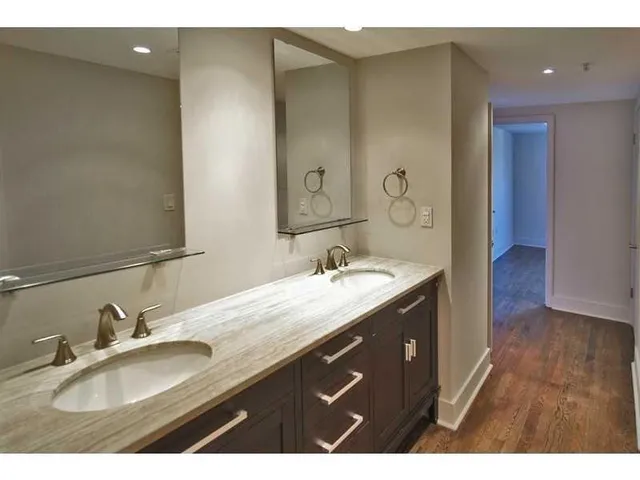 a bathroom with a granite countertop sink a large mirror and shower