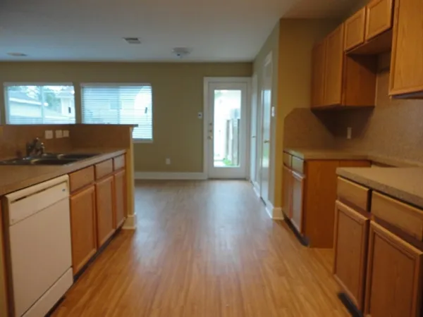 a kitchen with a sink and wooden floor