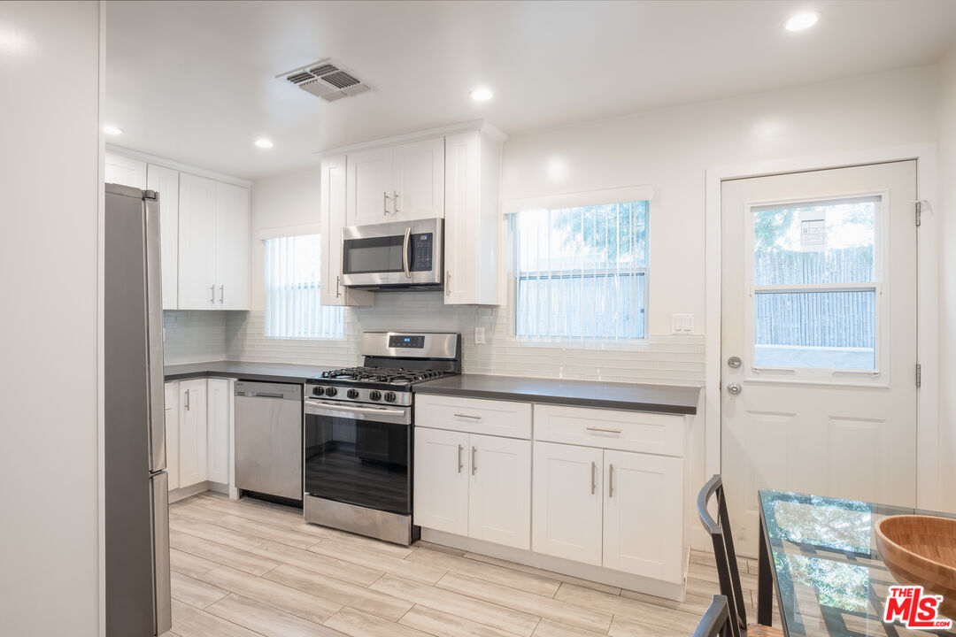 1024 Maple Street, Unit 1 Santa Monica, CA 90405 - Photo 4 of 16 a kitchen with stainless steel appliances granite countertop a stove a sink and a microwave