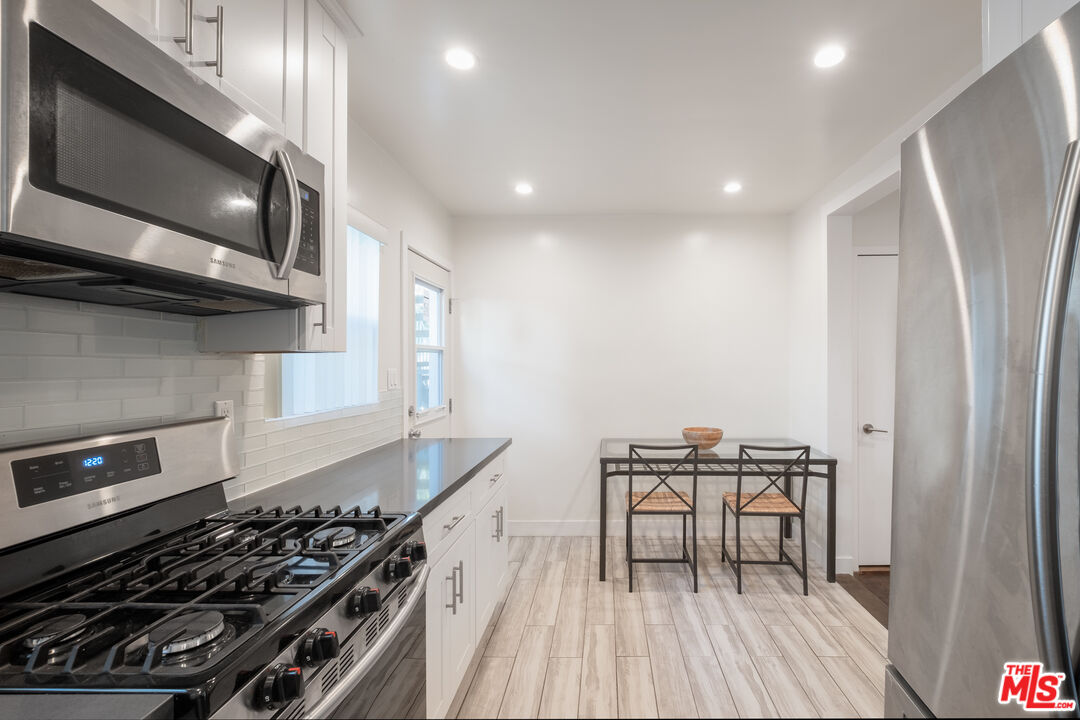 1024 Maple Street, Unit 1 Santa Monica, CA 90405 - Photo 6 of 16 a kitchen with granite countertop a stove and a wooden floor
