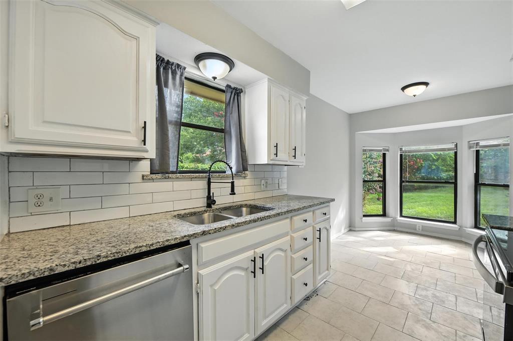 602 Valleyridge Court Decatur, TX 76234 - Photo 5 of 27 a kitchen with granite countertop a sink and a window