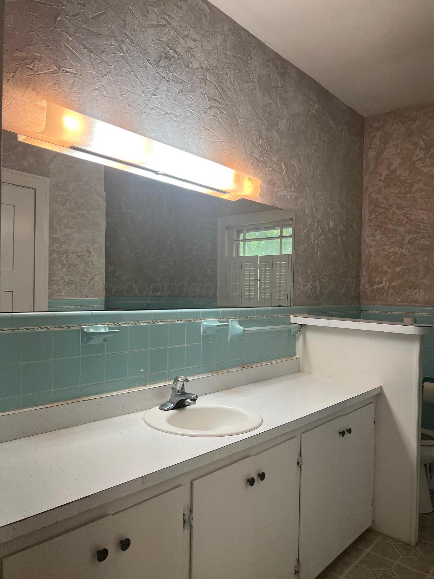 920 Montgomery Street Memphis, TX 79245 - Photo 17 of 30 a bathroom with a sink and a mirror