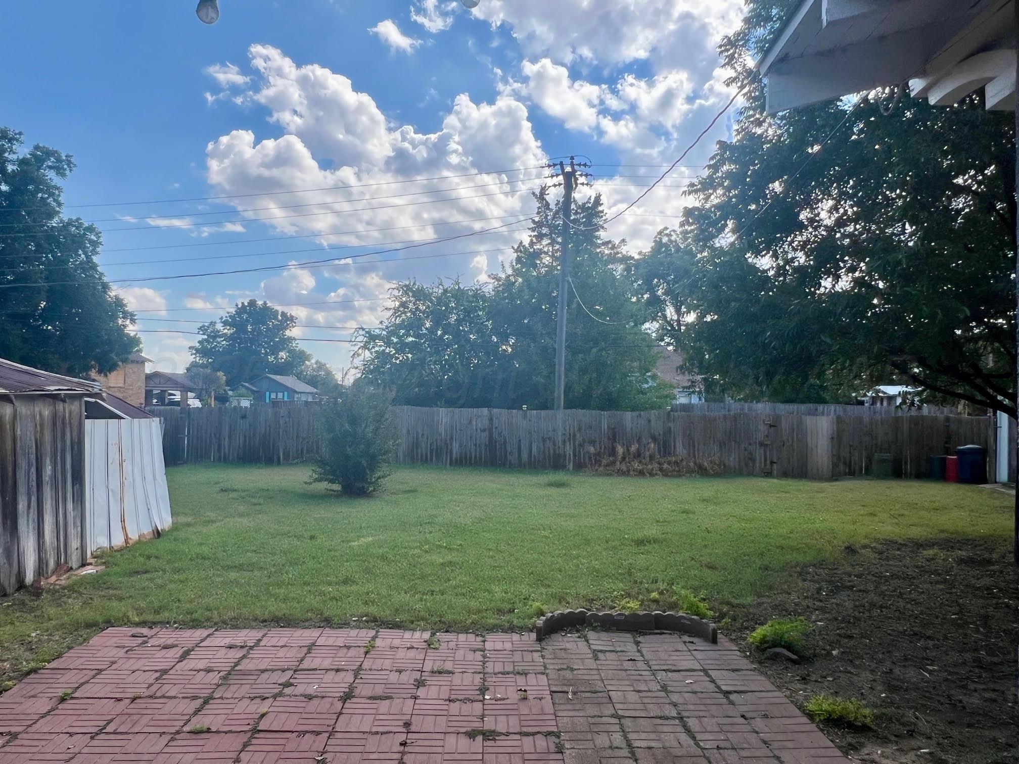 920 Montgomery Street Memphis, TX 79245 - Photo 27 of 30 a view of a backyard with potted plants and wooden fence