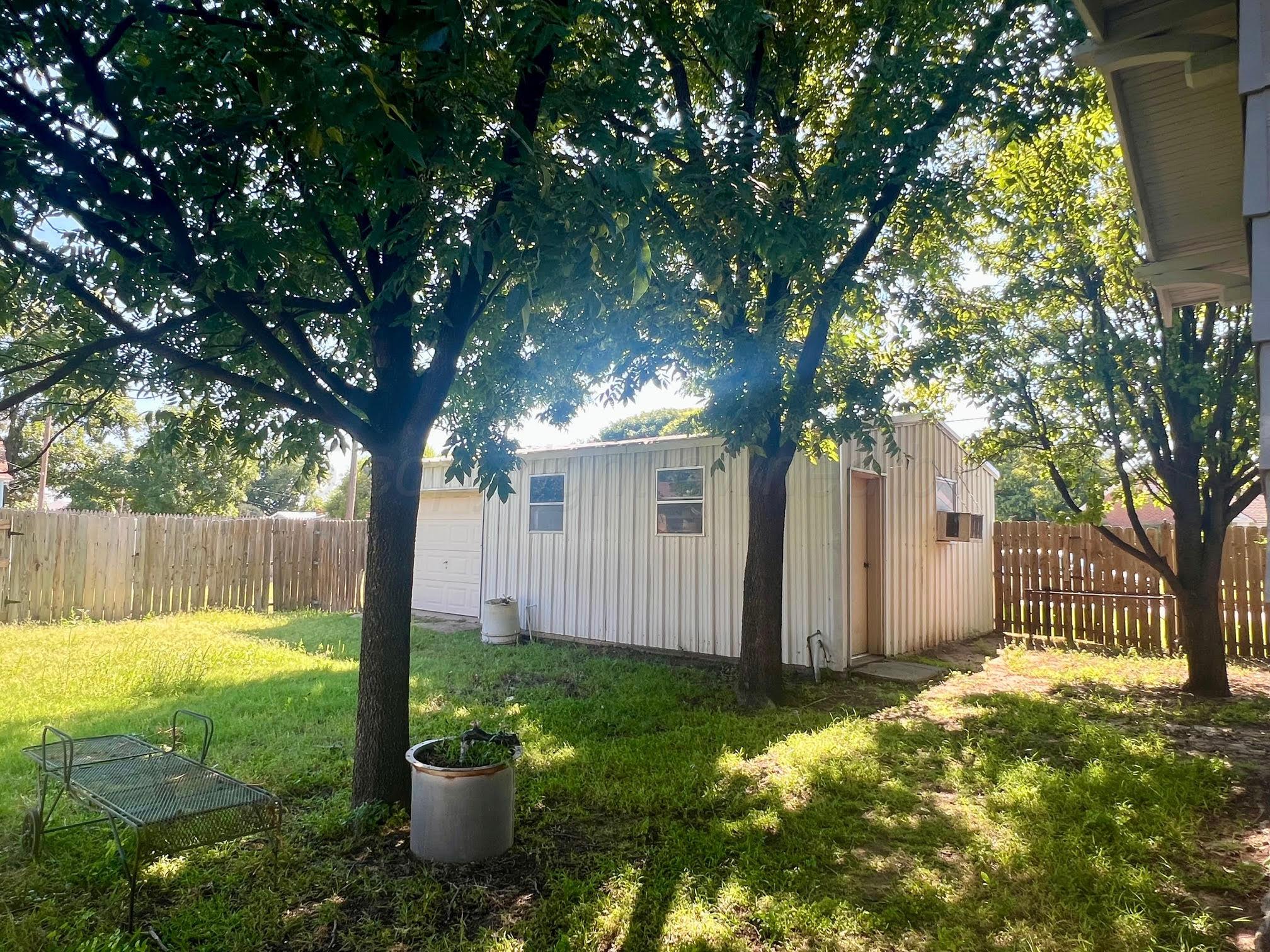 920 Montgomery Street Memphis, TX 79245 - Photo 29 of 30 a view of a backyard with large trees and a large tree