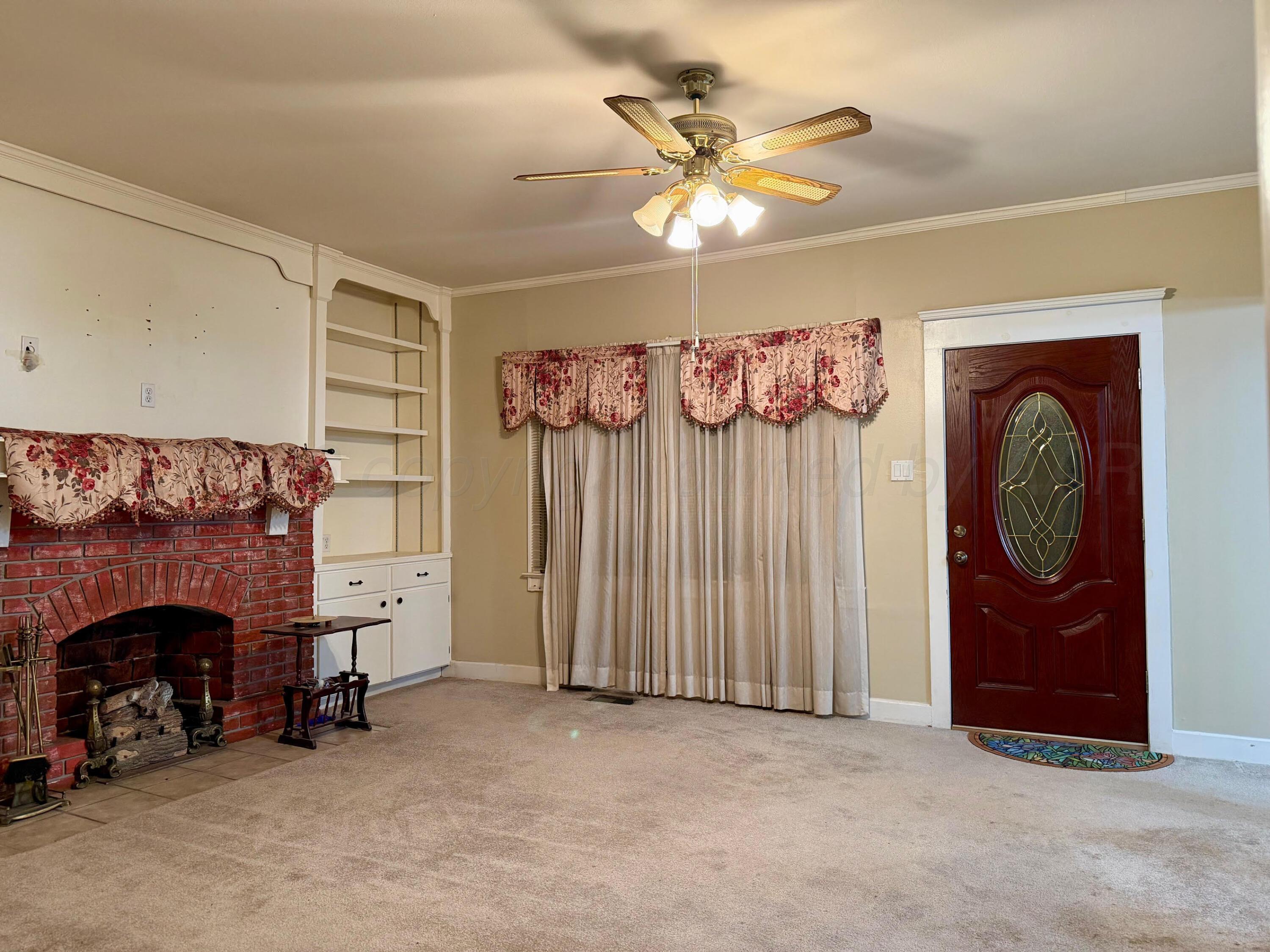 920 Montgomery Street Memphis, TX 79245 - Photo 3 of 30 an empty room with windows and fireplace