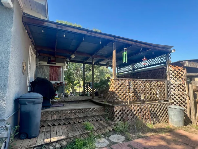 a view of a backyard with potted plants and wooden fence