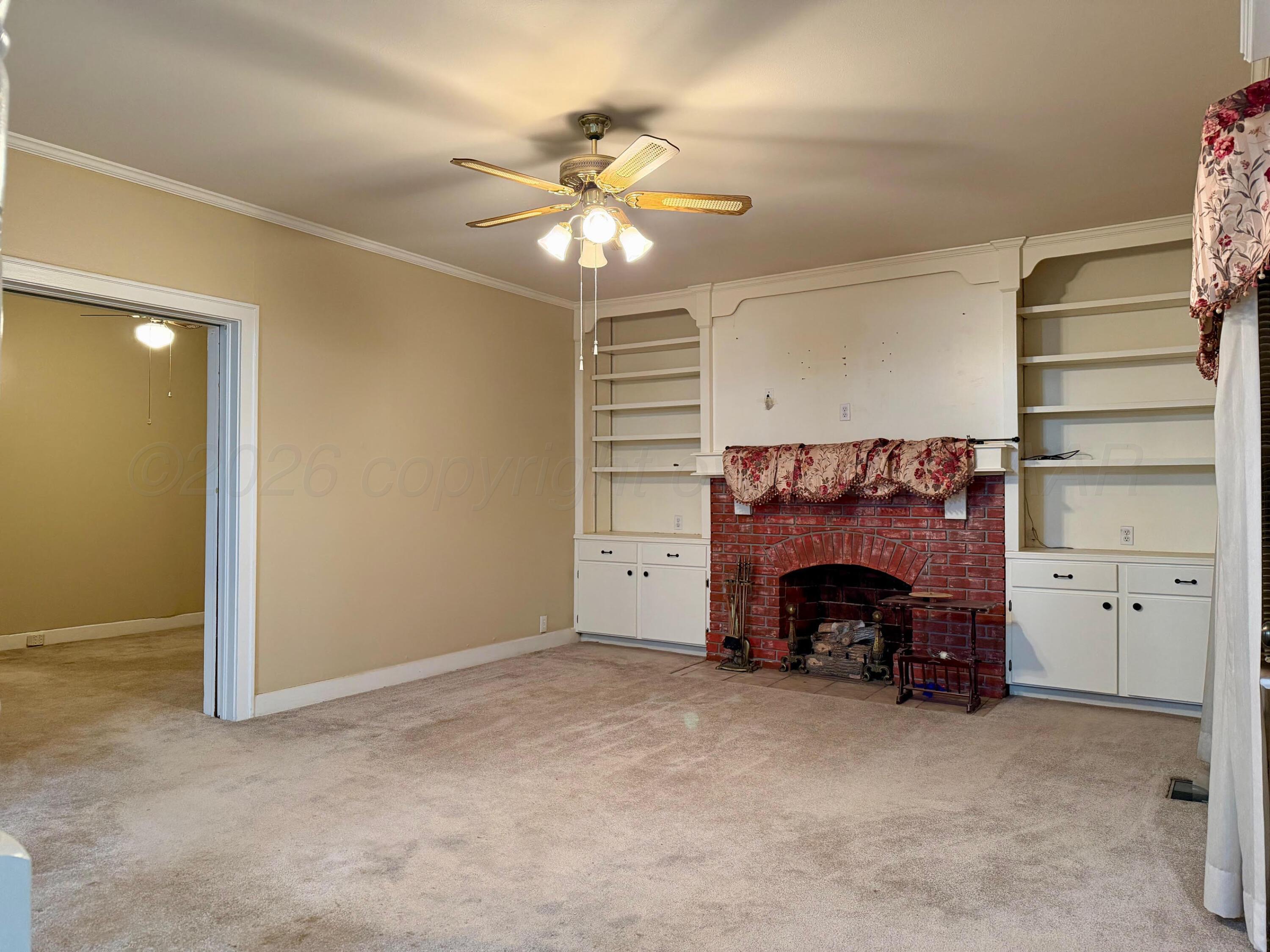 920 Montgomery Street Memphis, TX 79245 - Photo 4 of 30 an empty room with fireplace and fan