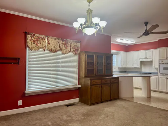 a kitchen with cabinets and chandelier