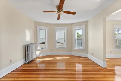 a view of empty room with window and ceiling fan