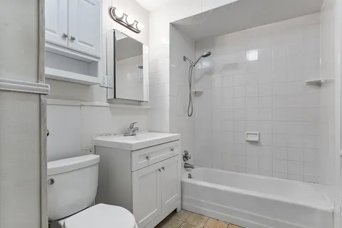 a bathroom with a granite countertop toilet a sink and a bathtub