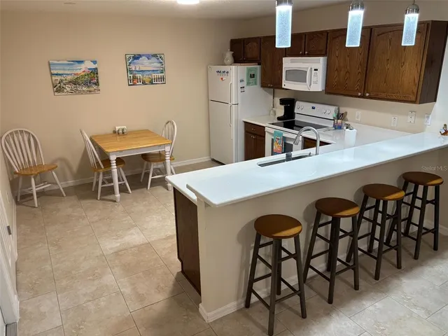 a living room with stainless steel appliances furniture a refrigerator and kitchen island