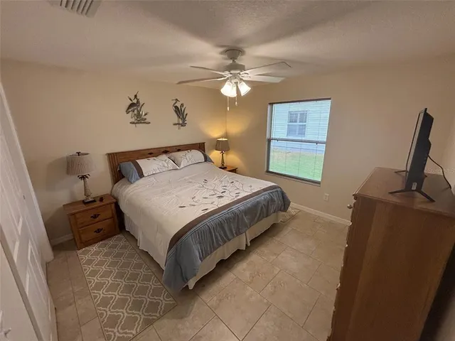 a bedroom with a bed and a flat tv screen on the dresser