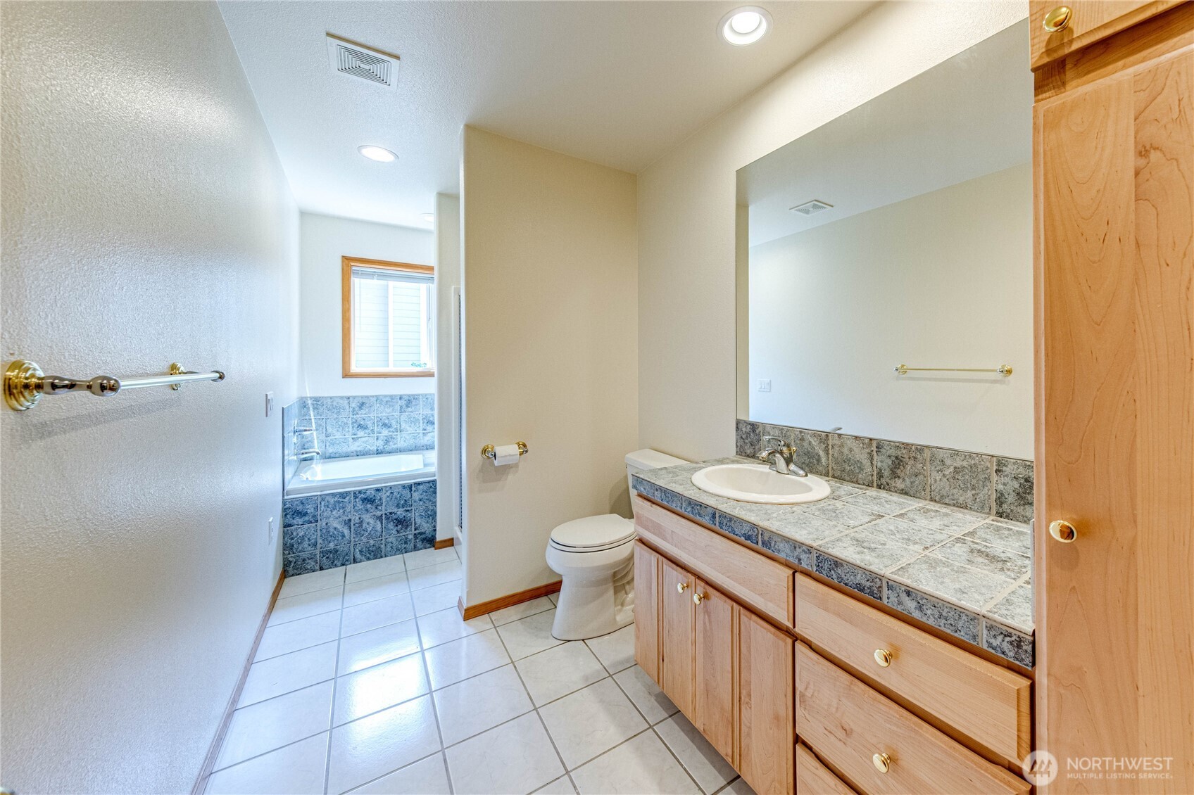 109 Vancouver Place Sequim, WA 98382 - Photo 22 of 40 a bathroom with a granite countertop sink a toilet a mirror and shower