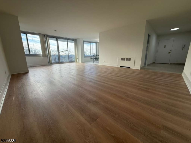 1 Claridge Drive, Unit 428 Verona, NJ 07044 - Photo 11 of 17 an empty room with wooden floor and windows