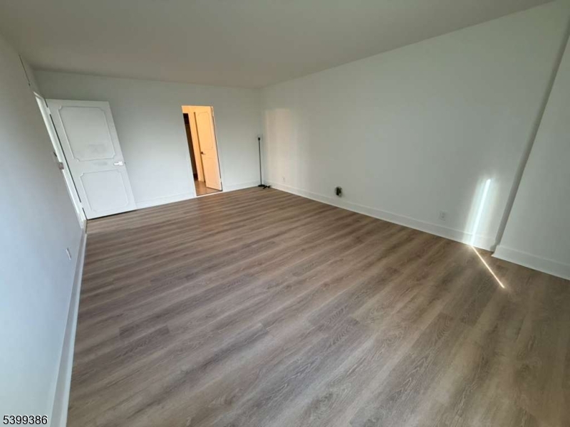 1 Claridge Drive, Unit 428 Verona, NJ 07044 - Photo 14 of 17 a view of empty room with wooden floor