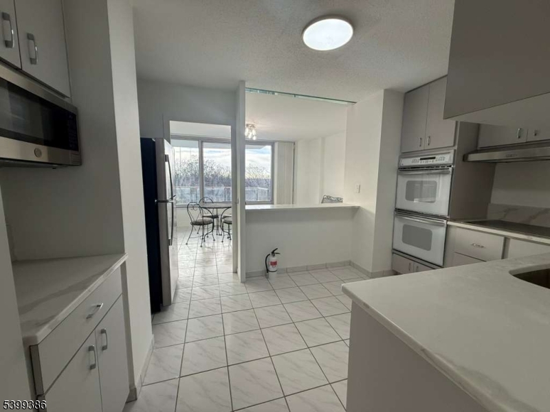 1 Claridge Drive, Unit 428 Verona, NJ 07044 - Photo 8 of 17 a kitchen with stainless steel appliances a sink a stove and cabinets