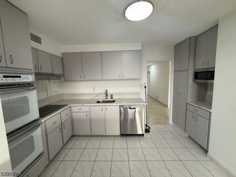 1 Claridge Drive, Unit 428 Verona, NJ 07044 - Photo 9 of 17 a kitchen with a stove sink and cabinets