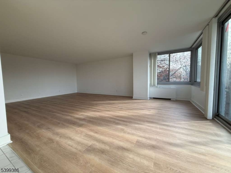 1 Claridge Drive, Unit 428 Verona, NJ 07044 - Photo 10 of 17 wooden floor in an empty room with a window