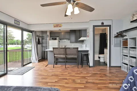 a room with stainless steel appliances kitchen island granite countertop a refrigerator and cabinets