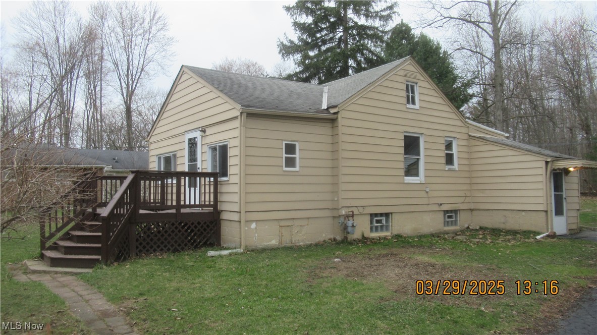 36505 Pettibone Road Solon, OH 44139 - Photo 2 of 24 View of side of property with roof with shingles, a deck, and a yard